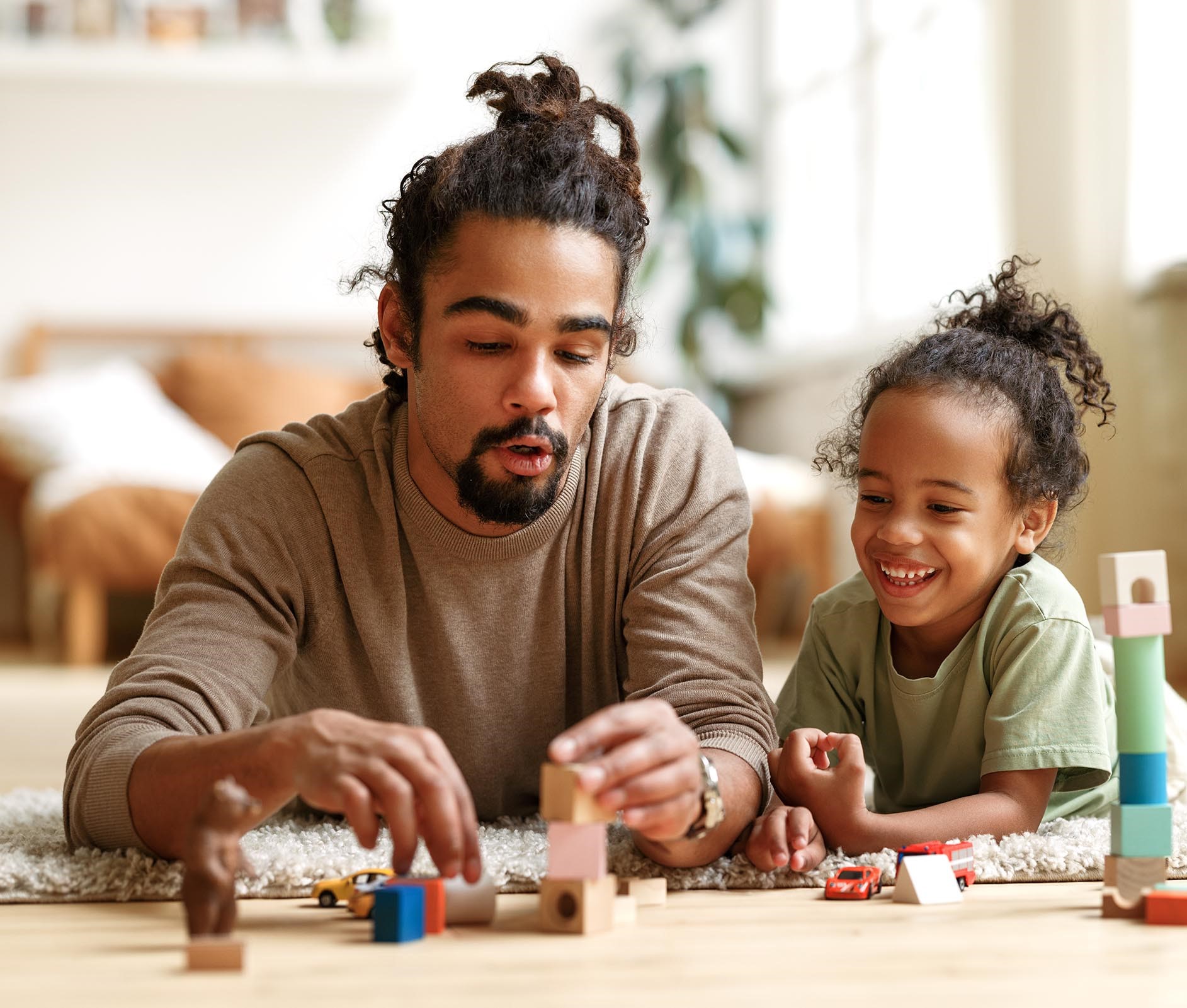 young african amercian father playing blocks with daughter