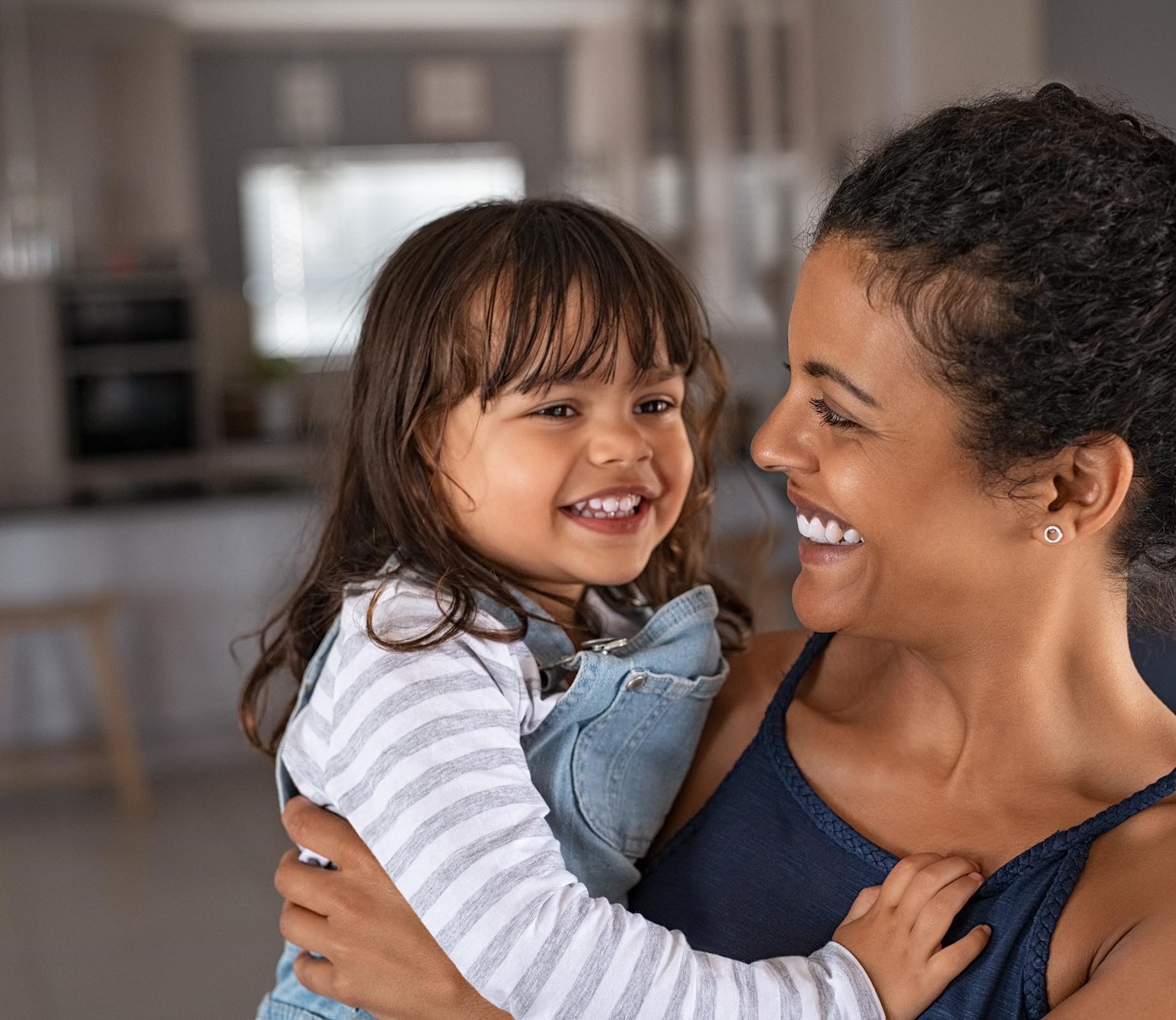 young smiling mother holding her daughter