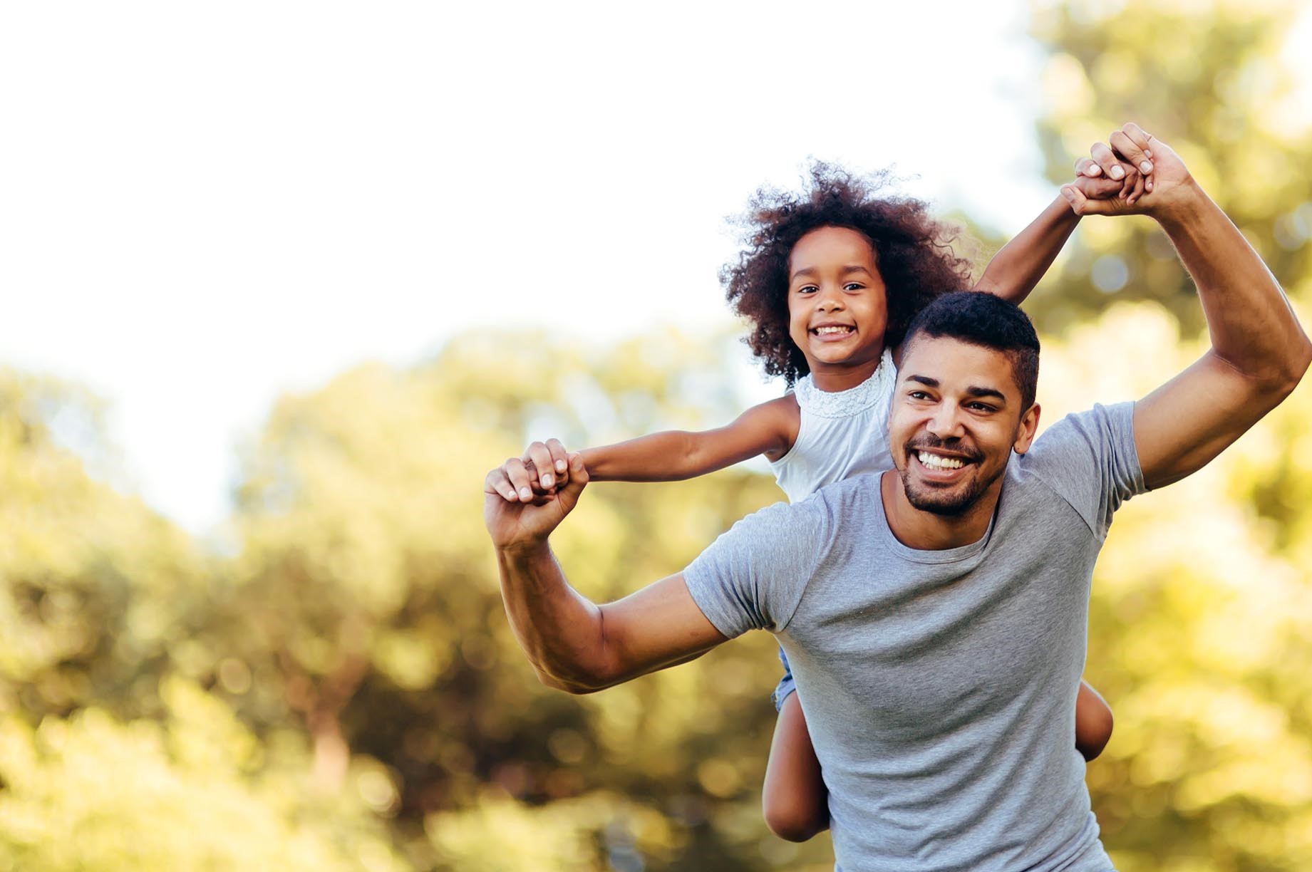 father with smiling girl on his shoulders