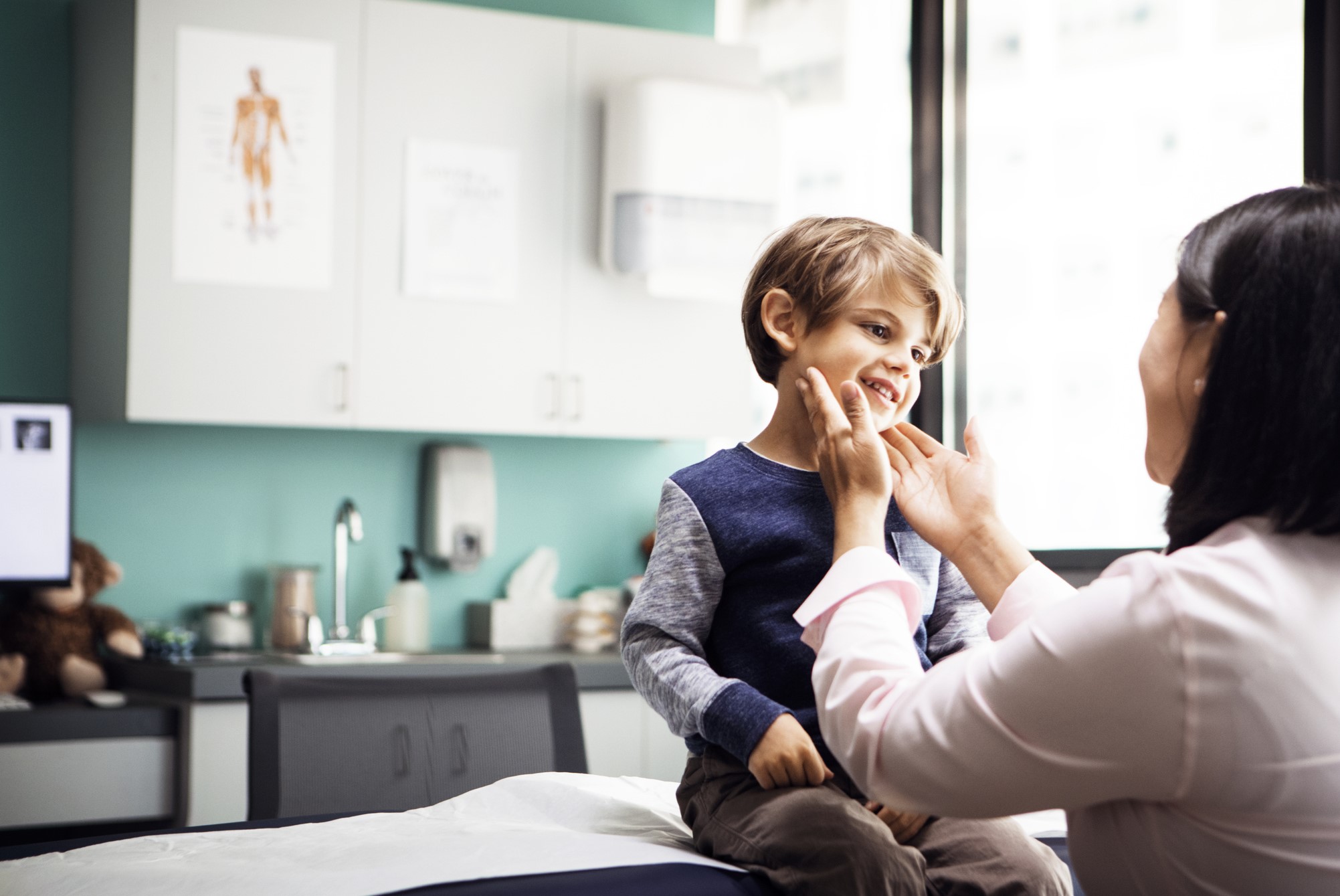 Little boy's neck being examined by a female doctor