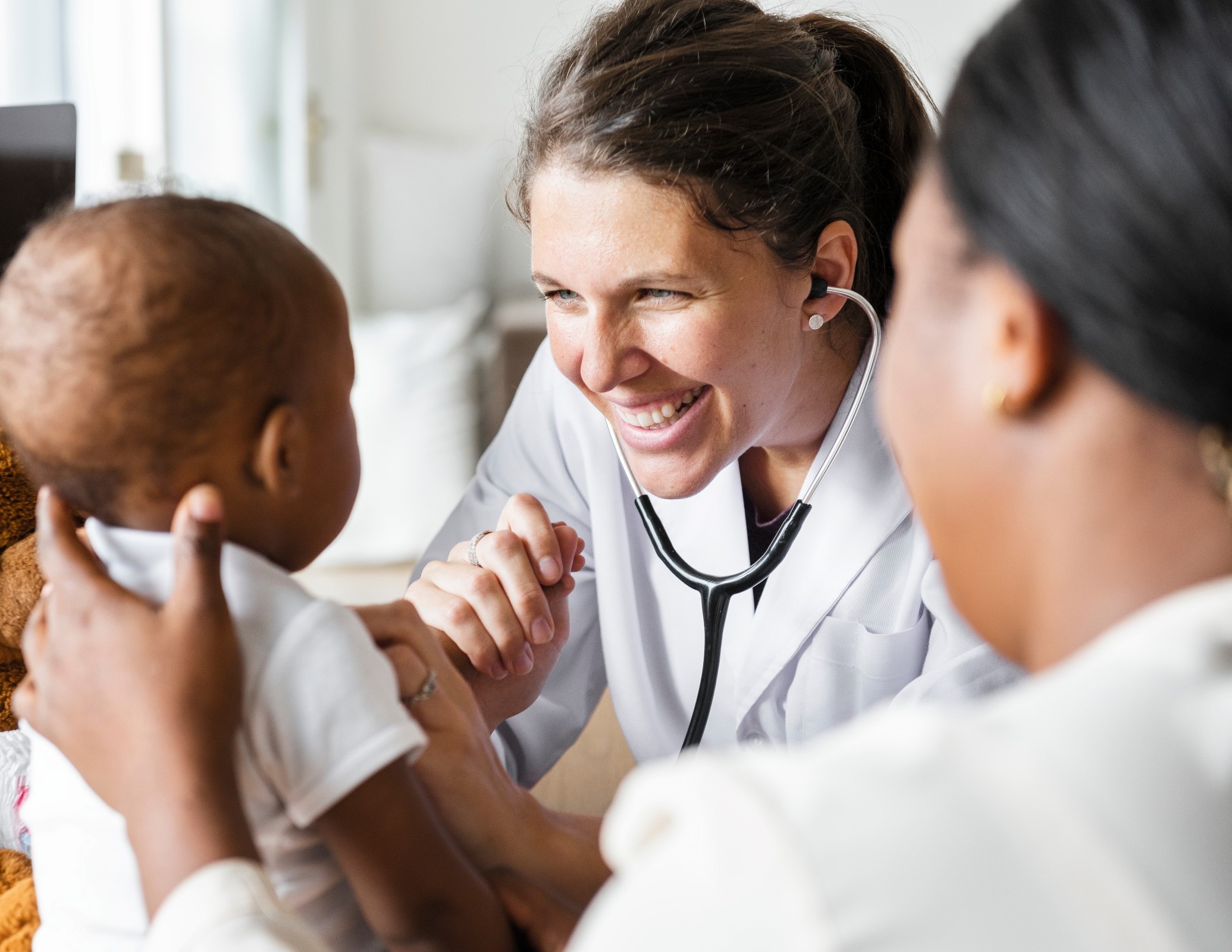 Smiling female doctor examining a baby